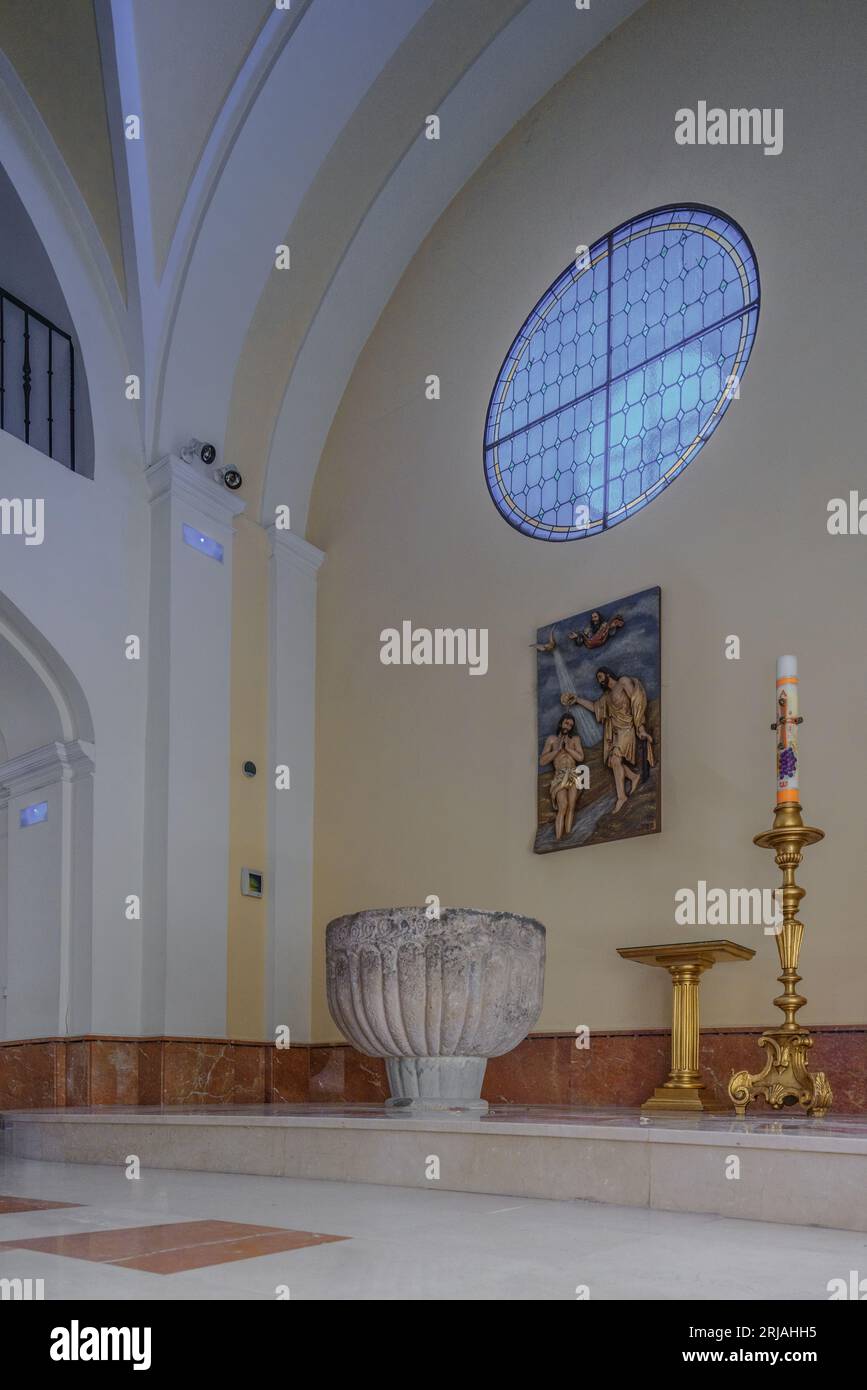 Battistero: Fonte battesimale, stile romanico, candela pasquale e altorilievo in legno del battesimo di Gesù di San Giovanni Battista, Guadalajara Foto Stock