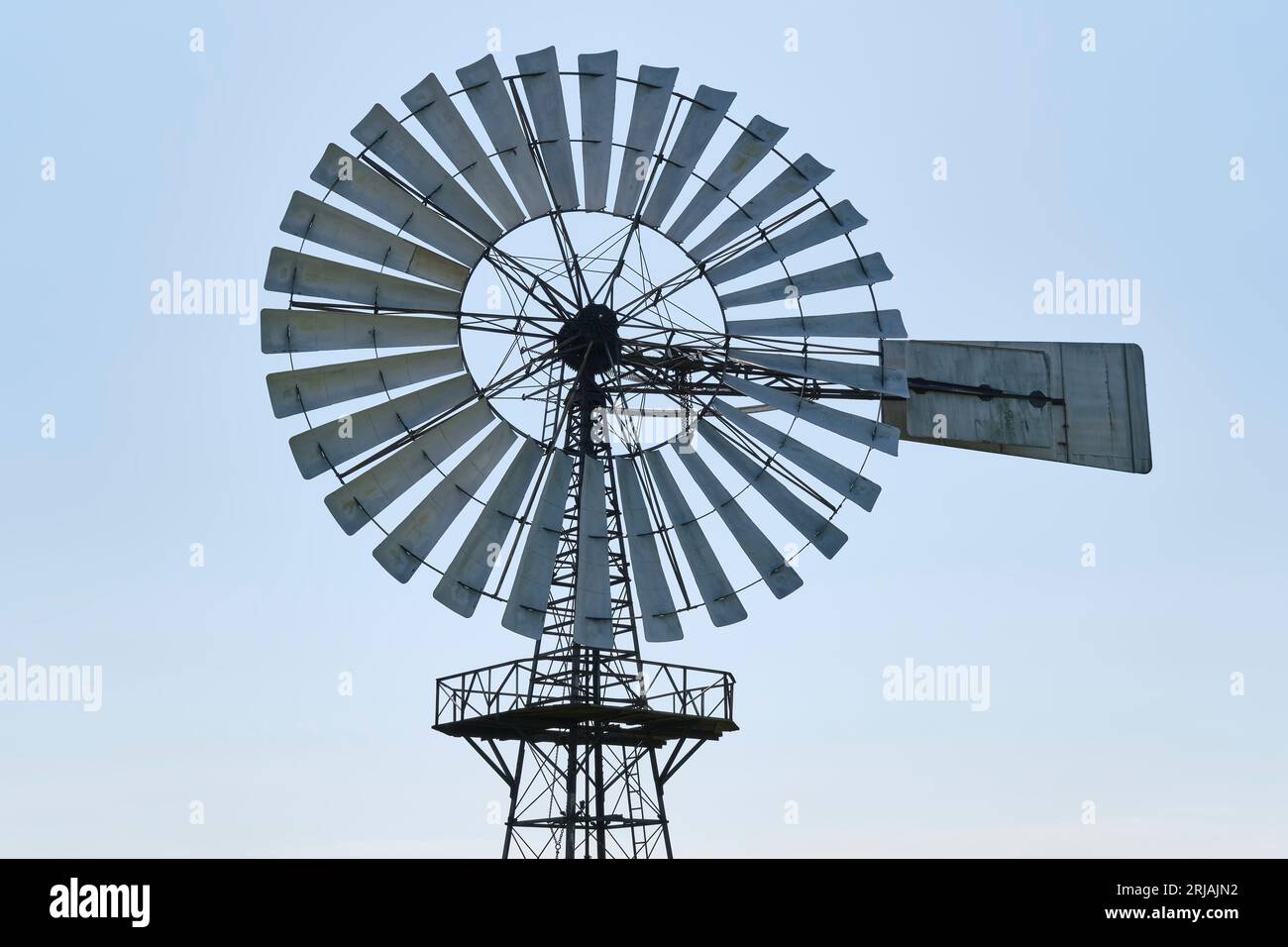 Le lame metalliche di un motore eolico americano sotto un cielo blu. Foto Stock