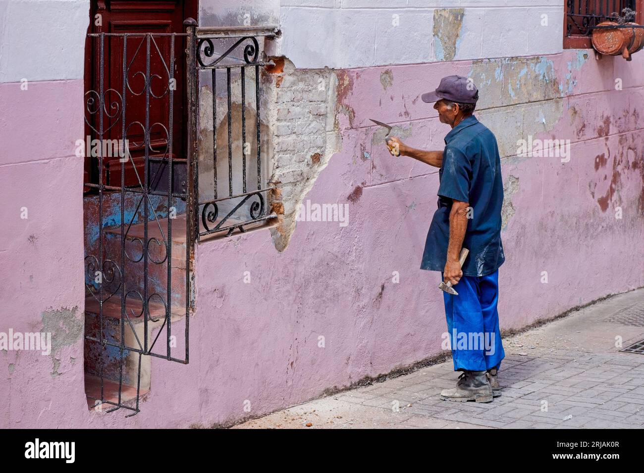 L'Avana, Cuba, un anziano muratore che si prepara a riparare una facciata della casa. Foto Stock