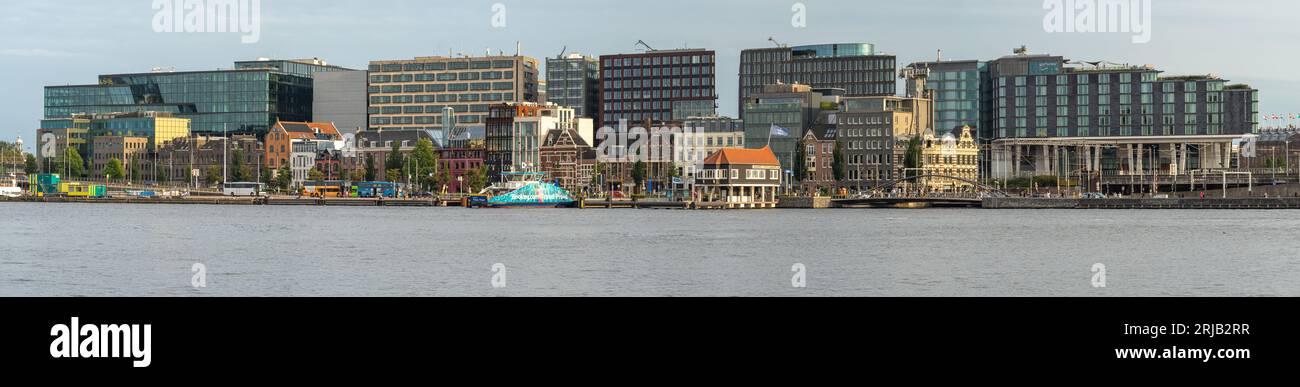 Amsterdam, Paesi Bassi, 16.08.2023, panorama sul lungomare di Amsterdam, vista degli edifici moderni e del terminal dei traghetti di De Ruijterkade By Foto Stock
