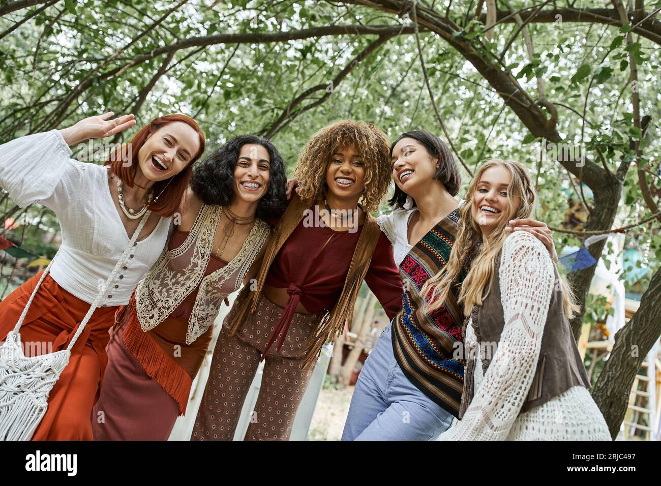 gruppo di amiche alla moda e interrazziali che guardano la macchina fotografica all'aperto nel centro di ritiro Foto Stock