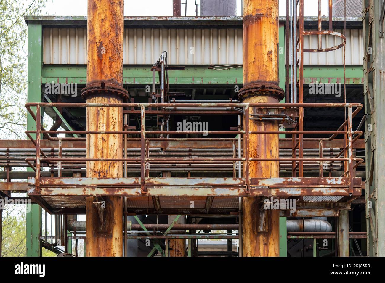 Primo piano dell'edificio con sistema di tubazioni arrugginite e intemperie e attrezzature di una acciaieria industriale abbandonata e fatiscente nei Landschaft pubblici Foto Stock