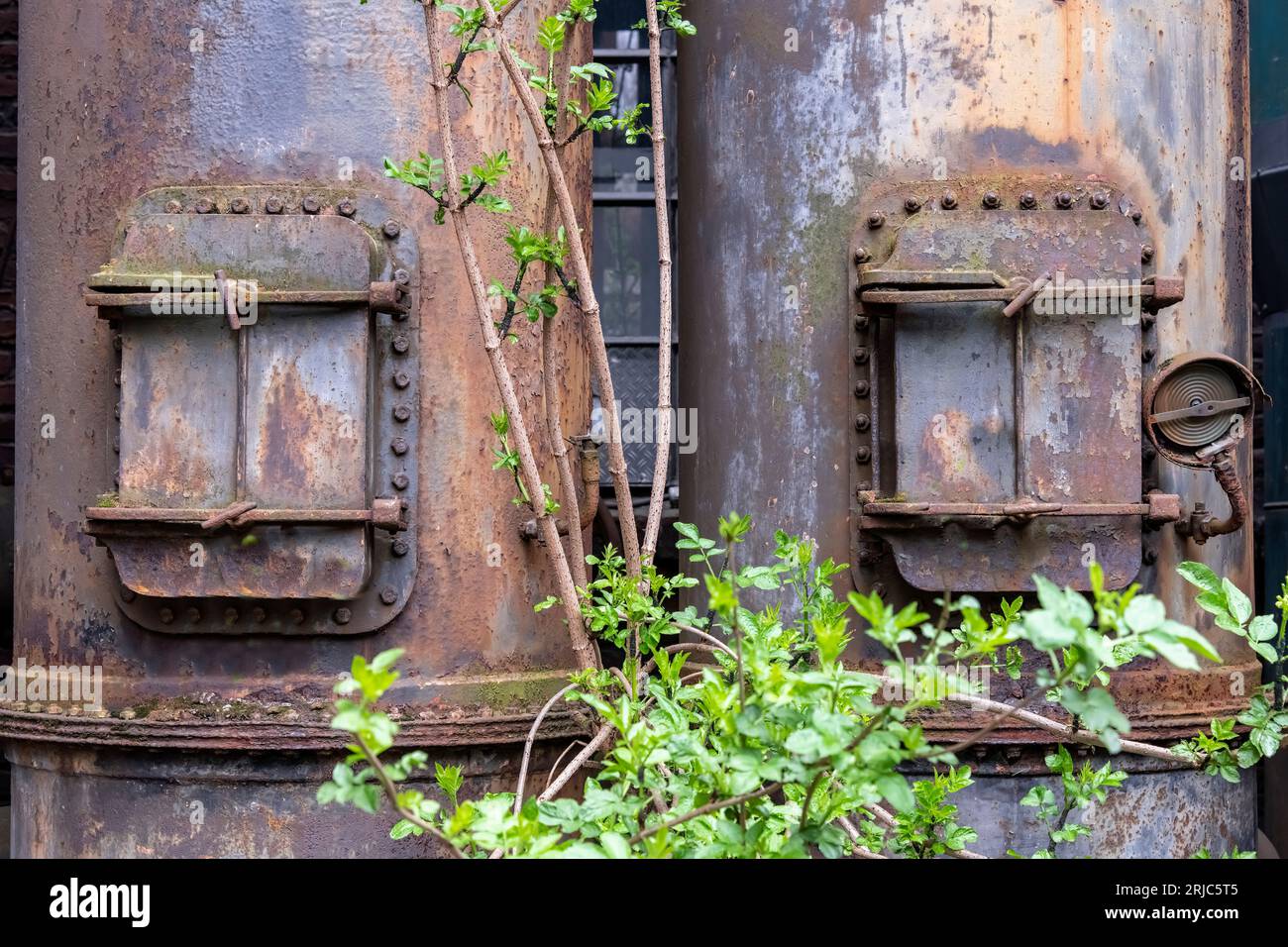 Primo piano di forni arrugginiti o sistemi di tubazioni con porte in acciaio di una acciaieria industriale abbandonata e fatiscente nei Landschaft pubblici Foto Stock