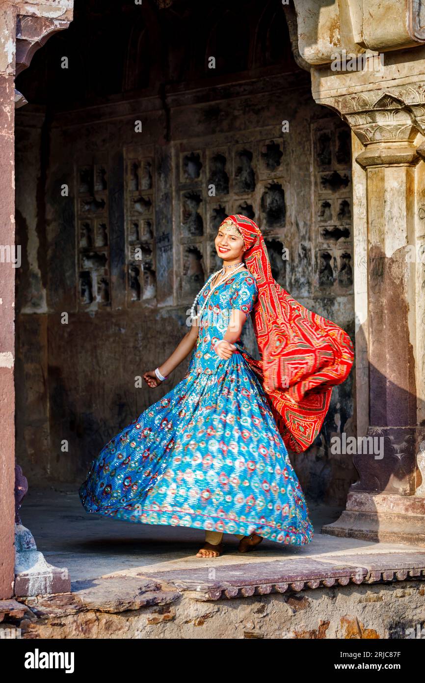 A pretty young local woman wearing a local style red veil and blue dress in Ranthambore Fort, Ranthambore National Park, Rajasthan, northern India Foto Stock