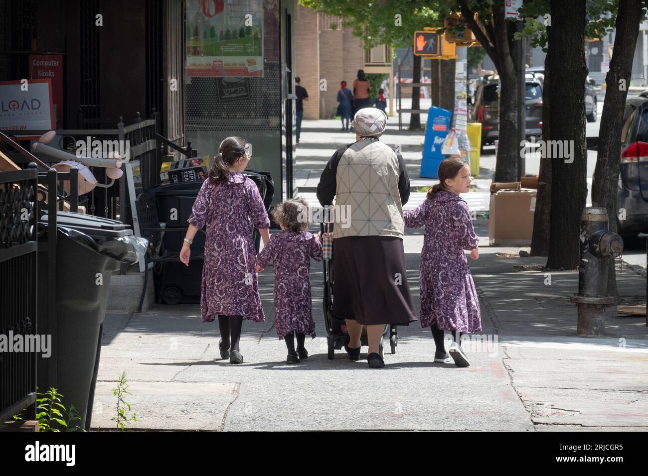 Una madre ebrea ultra ortodossa e le sue 3 figlie, ognuna con lo stesso vestito identico. A Williamsburg, Brooklyn, New York. Foto Stock