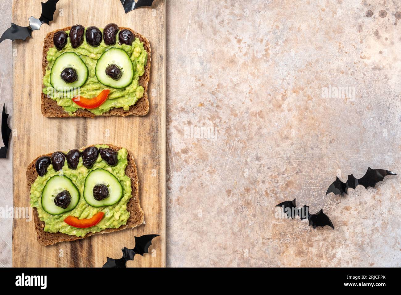 Brindisi con un mostro verde di avocado per Halloween Foto Stock