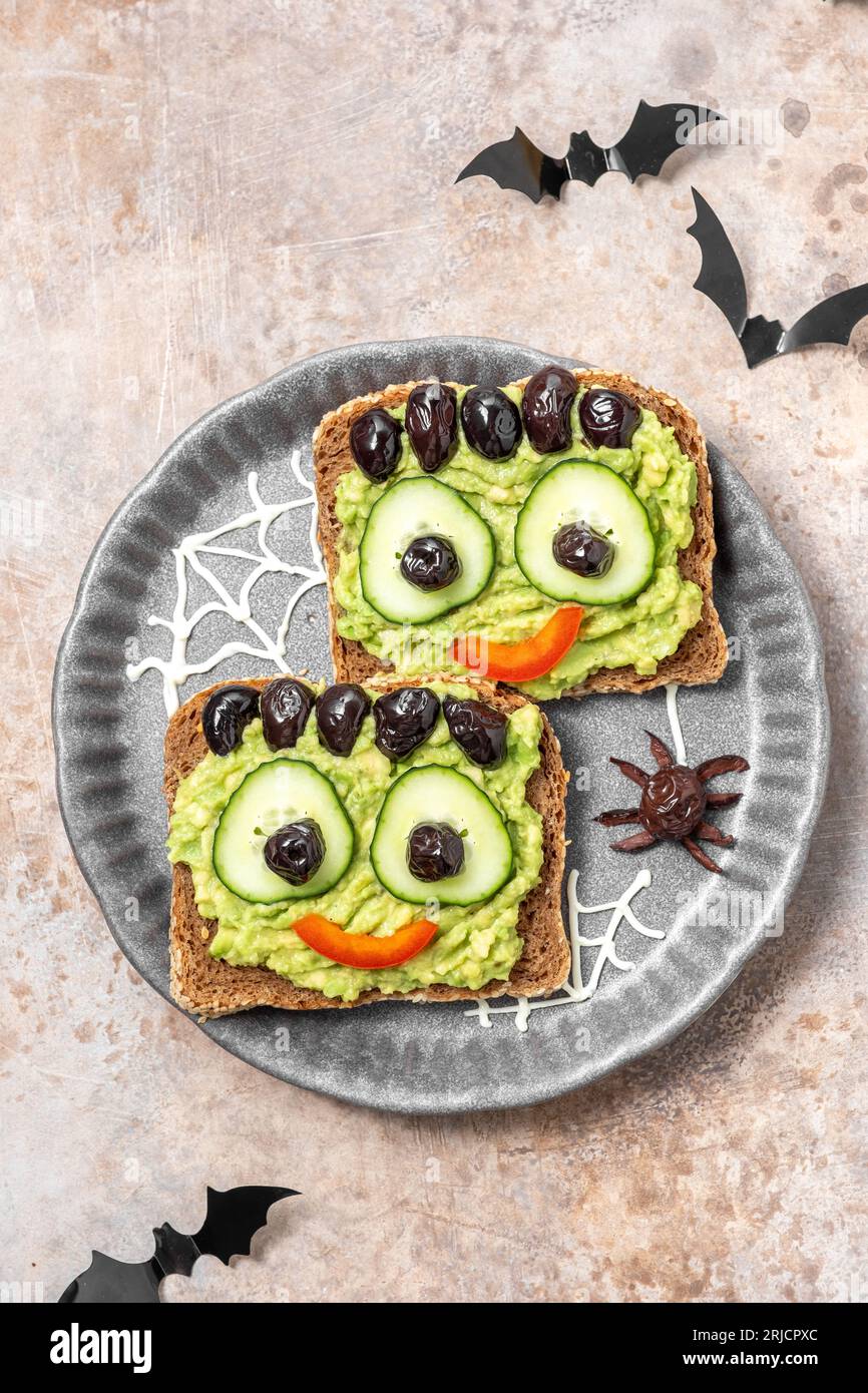 Brindisi con un mostro verde di avocado per Halloween Foto Stock