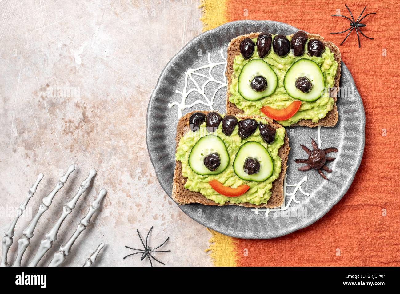 Brindisi con un mostro verde di avocado per Halloween Foto Stock