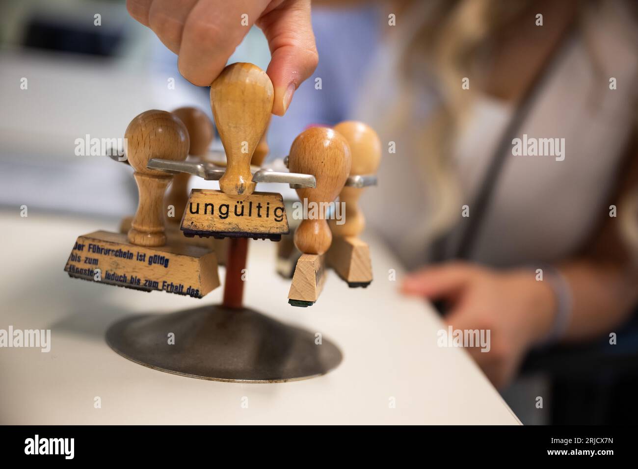 Berlino, Germania. 22 agosto 2023. Una donna prende un francobollo contrassegnato come "non valido" da un titolare di francobollo dell'Ufficio per la cittadinanza dell'istruzione. Credito: Sebastian Christoph Gollnow/dpa/Alamy Live News Foto Stock