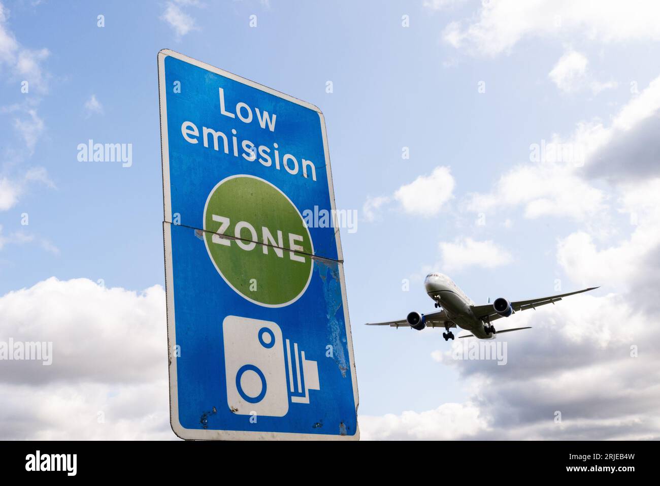 Cartello zona a bassa emissione con atterraggio di un jet plane all'aeroporto di Londra Heathrow, Regno Unito. Inquinamento atmosferico. Emissioni di anidride carbonica. Emissioni del trasporto aereo. Segnale fotocamera Foto Stock