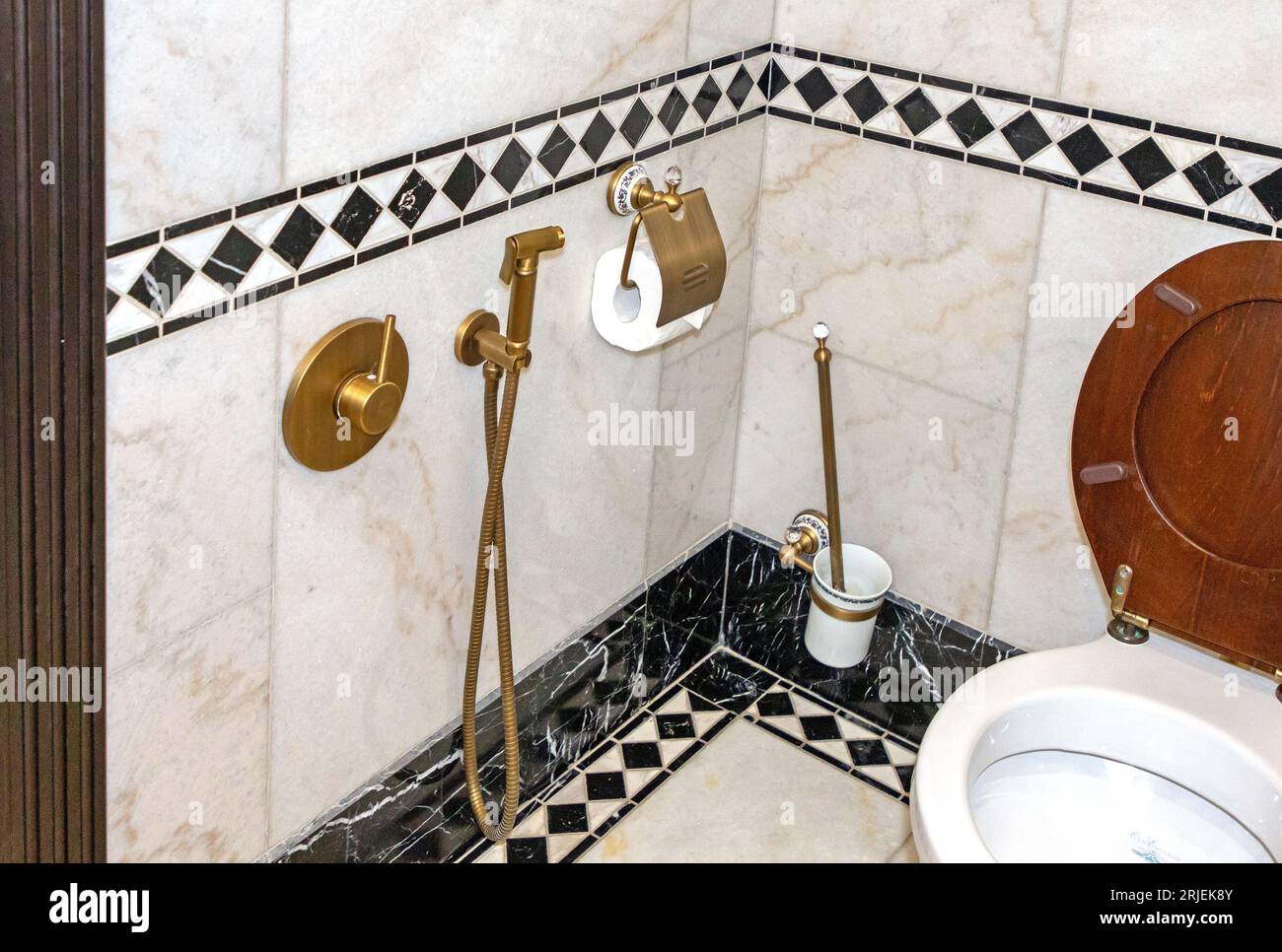 Piccolo. interno del bagno con wc in legno e piastrelle decorative Foto Stock