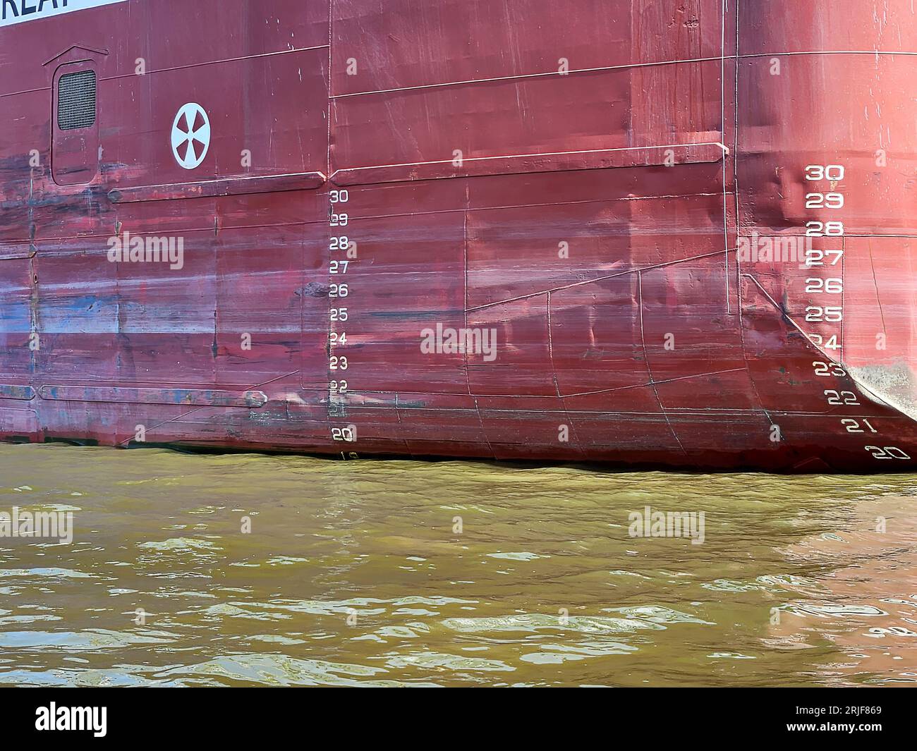 Marcatori di linea Plimsoll sullo scafo di una nave da carico in acqua verde Foto Stock