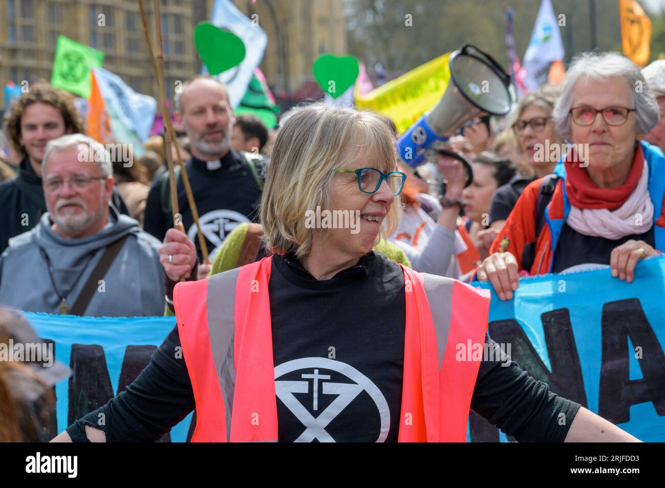 LONDRA - 22 aprile 2023: XR's Guiding Hand: A Londra, una donna steward conduce la strada alla manifestazione di protesta per l'estinzione della ribellione, incarnando la leadership Foto Stock