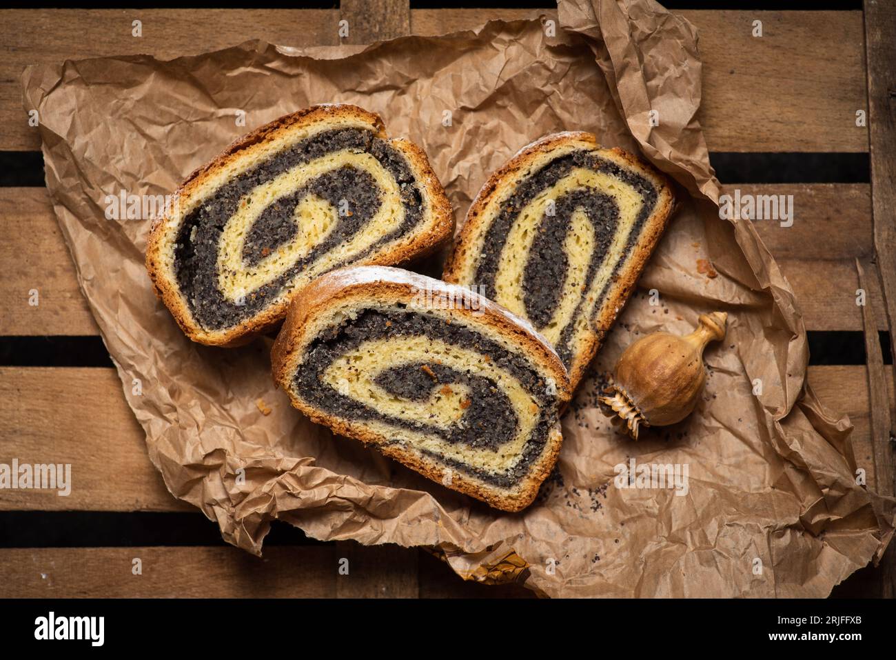 Frammenti di strudel fresco fatto in casa con semi di papavero su carta, vista dall'alto Foto Stock