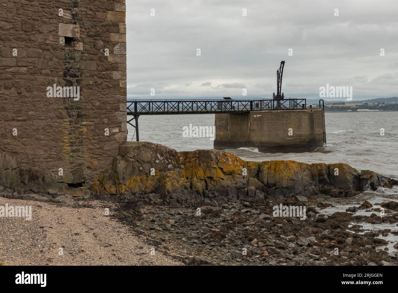 Molo storico con un ascensore a gru sulla riva del mare scozzese Foto Stock