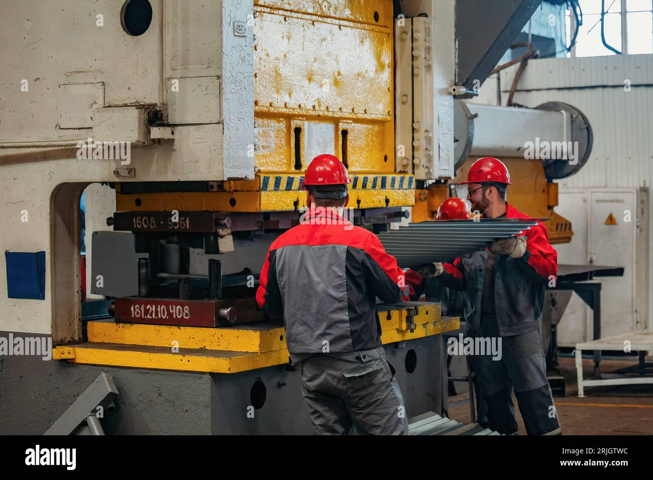 Operatori tecnici che lavorano con lamiera su pressa idraulica CNC. Foto Stock