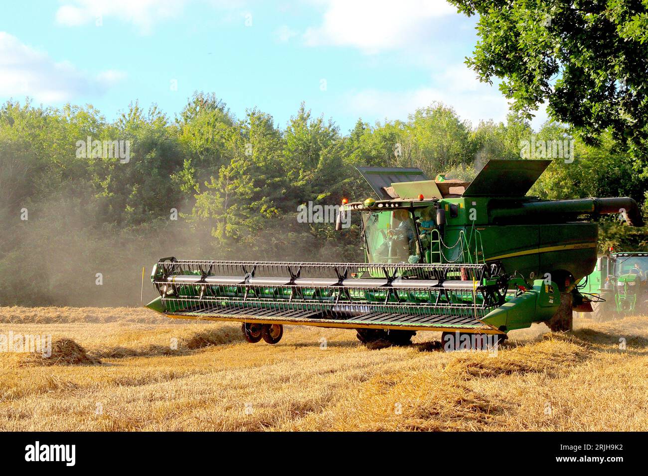 Una mietitrebbiatrice John Dere Hillmaster gira per continuare a tagliare una nuova fila di grano raccolto in un campo del Buckinghamshire, agosto 2023. Foto Stock