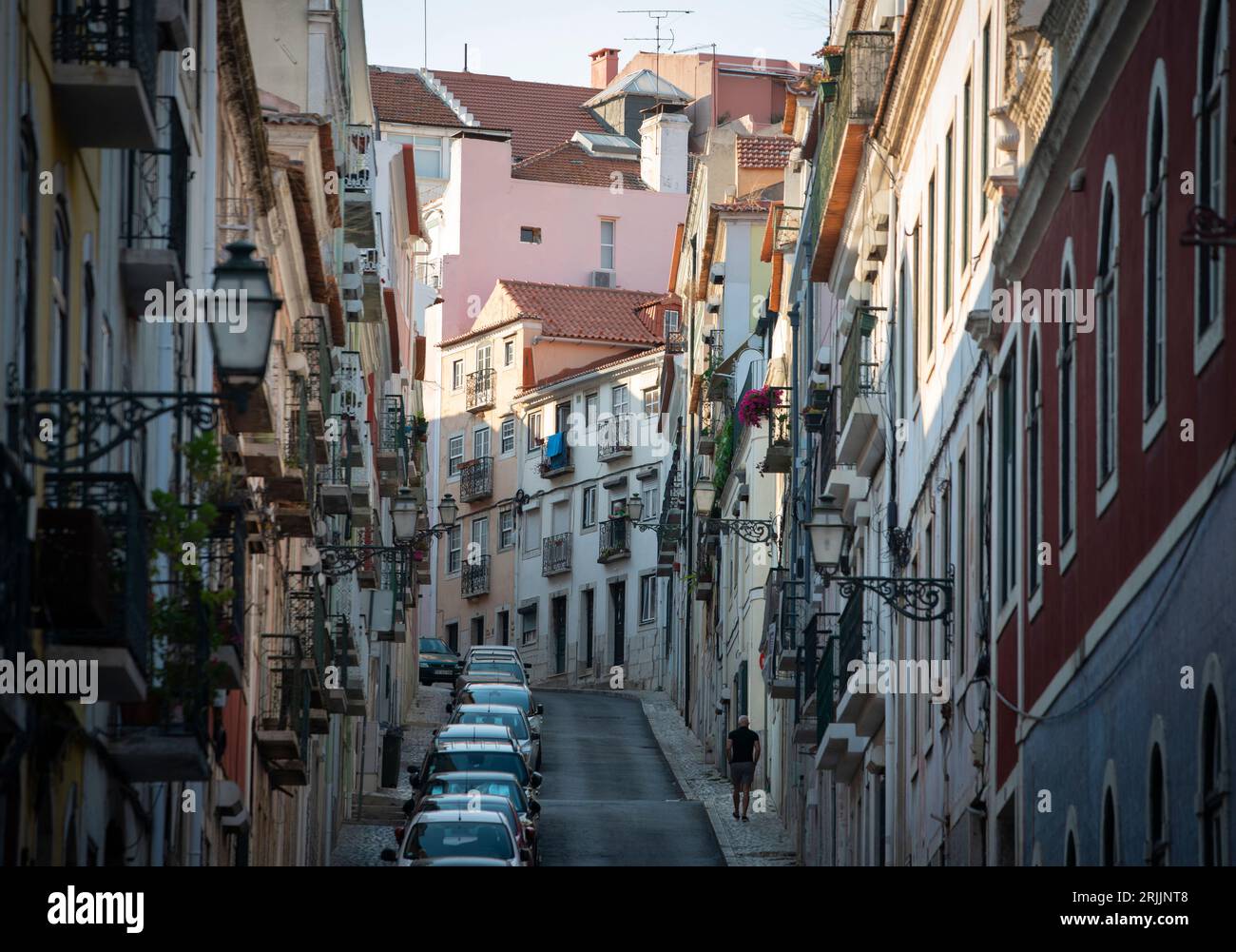 Domenica sera in Rue Manual Bernardes nel quartiere Principe Real di Lisbona, Portogallo. Un uomo solitario che cammina in salita su una delle strette strade della capitale portoghese. Foto Stock