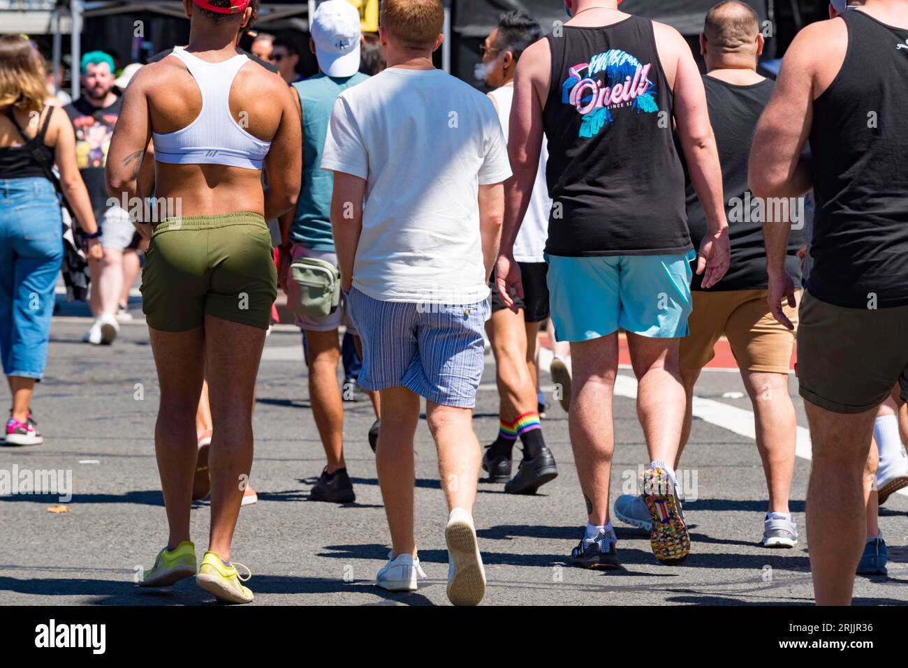 Persone (per lo più uomini) viste da dietro, camminando lungo Oxford Street, Darlinghurst nel Mardi Gras Day durante World Pride Sydney2023 Foto Stock