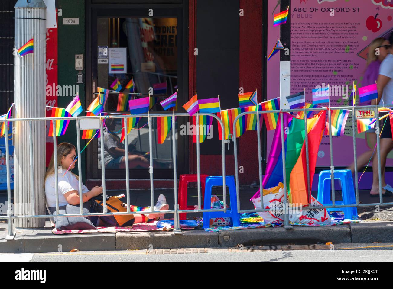 Le persone si sono allineate o sedute in attesa nel caldo di febbraio a Oxford Street, Sydney, in attesa che il LGBTQI+ Mardi Gras 2023 inizi più tardi quella sera Foto Stock