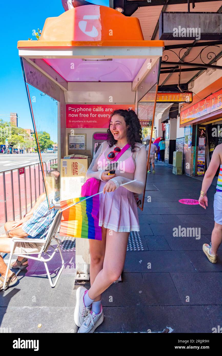 Una donna si rifugia in una cabina telefonica dal calore del pomeriggio di febbraio su Oxford Street, Darlinghurst nel giorno del Mardi Gras durante il World Pride Sydney 2023 Foto Stock