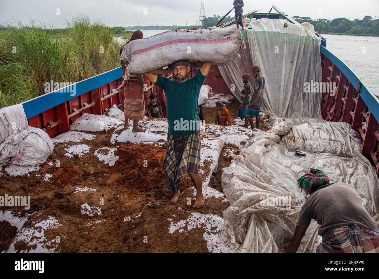 Le bucce di legno sono scaricate dalla barca. Questa foto è stata scattata il 14 settembre 2022, da Ruhitpur, Bangladesh Foto Stock