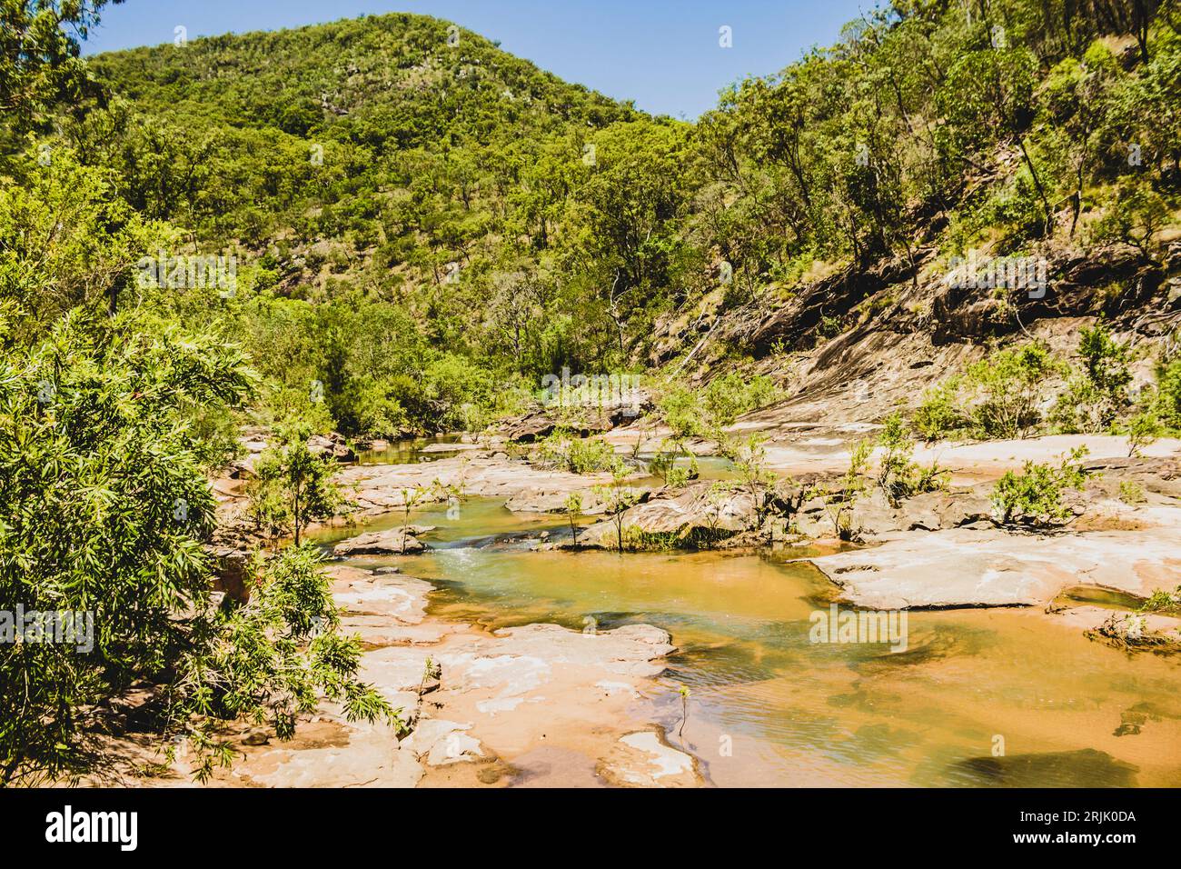 Tranquillo paesaggio remoto sulle acque che scorrono prima delle vette montuose del Monte Perry, Queensland, Australia Foto Stock