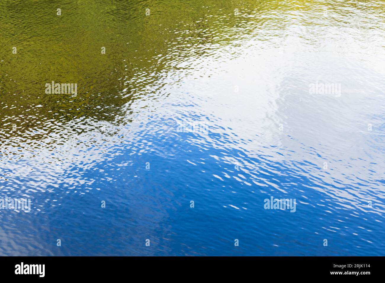 Superficie acquosa con riflessi naturali colorati su motivo ondulato, texture astratta della foto di sfondo Foto Stock