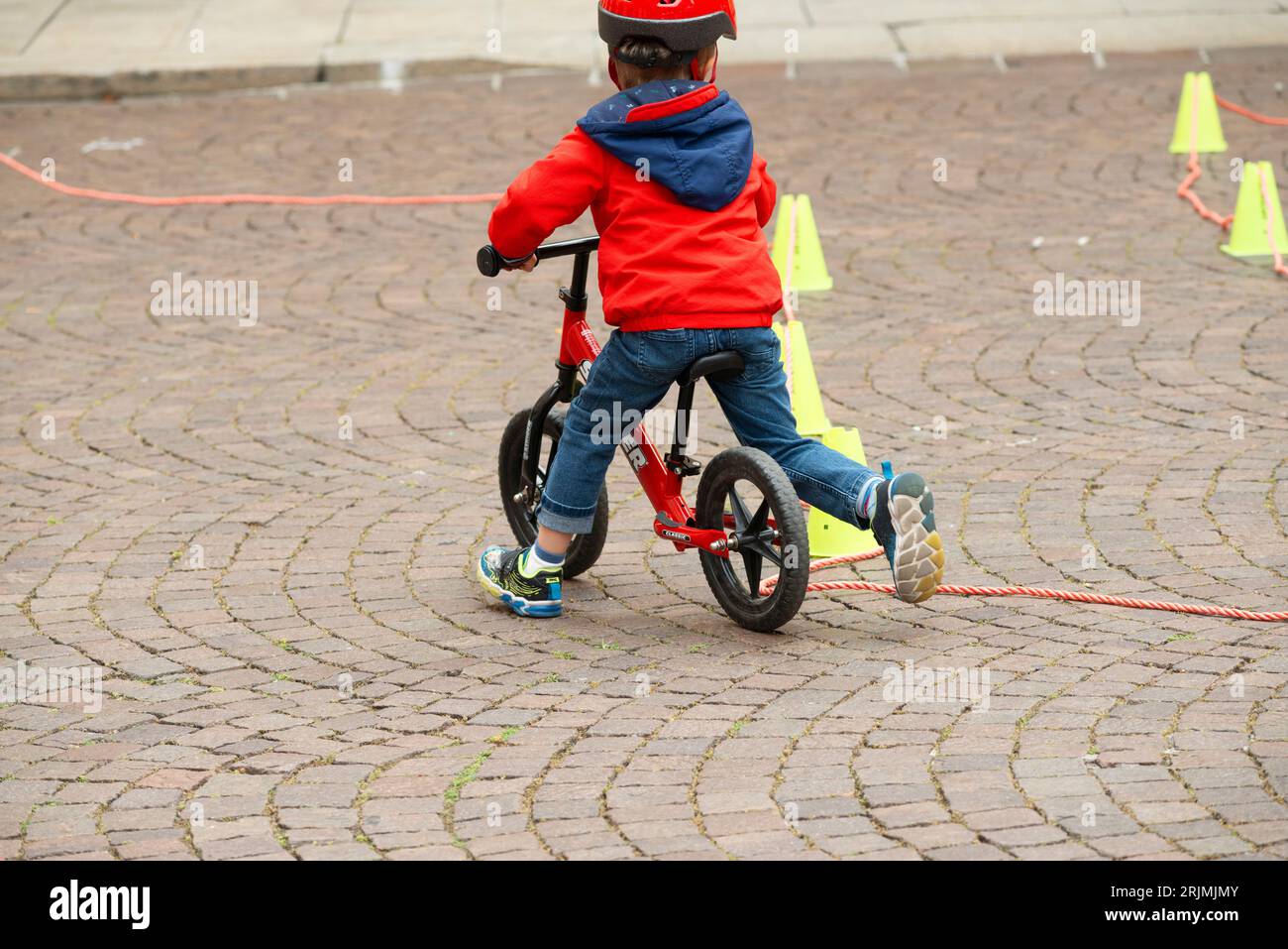 Baby Boy su Balance Bike con coni come pista Foto Stock