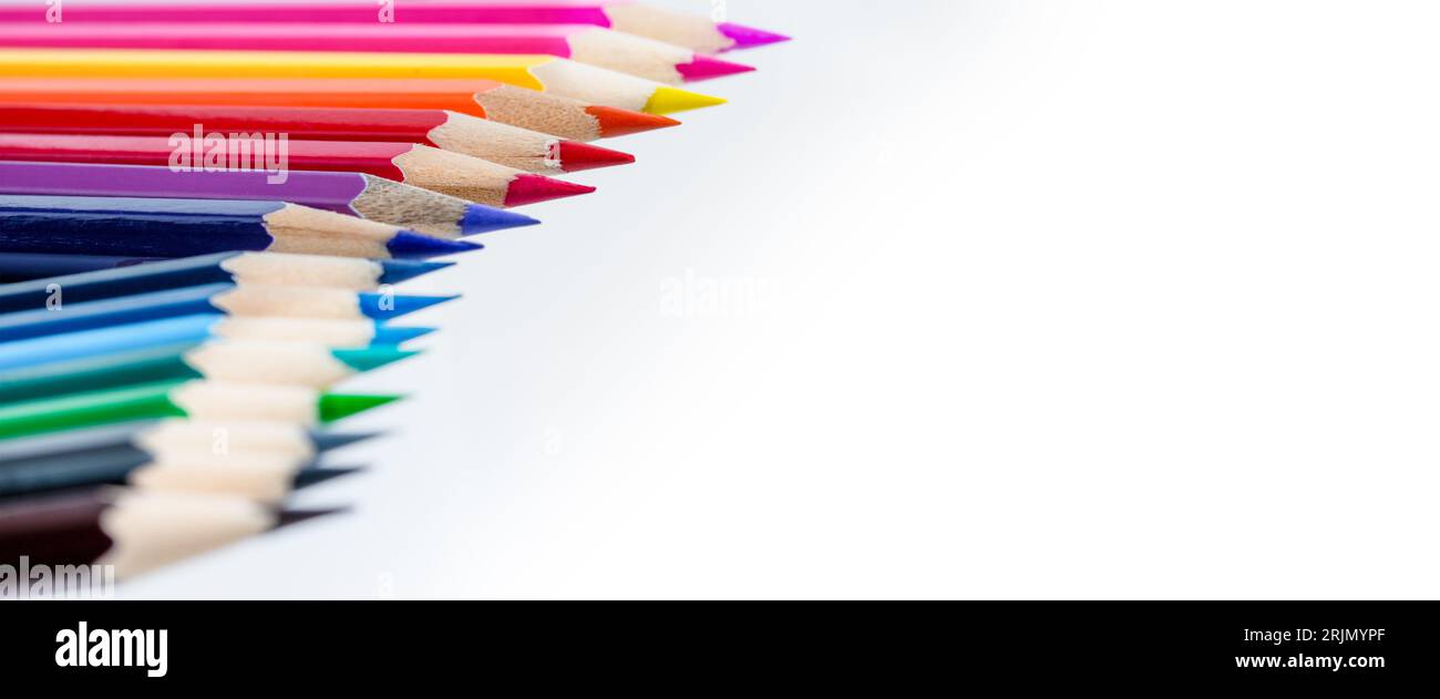 A row of colored pencils against a white background, designed to be used as border for page layout, with space for text. Foto Stock