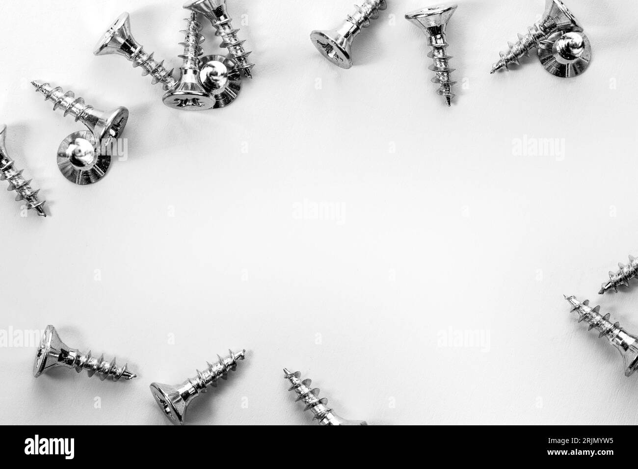 Viti cromate piene su sfondo metallico graffiato. Foto Stock