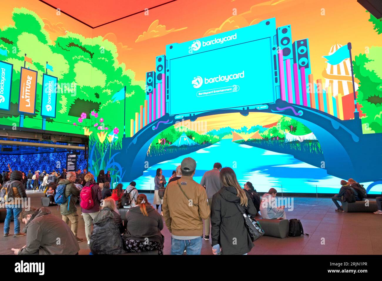 Persone in piedi che guardano un enorme display che pubblicizza Barclays Bank Barclaycard iat The Now Building Outernet in Charing Cross Road a Londra, Regno Unito Foto Stock