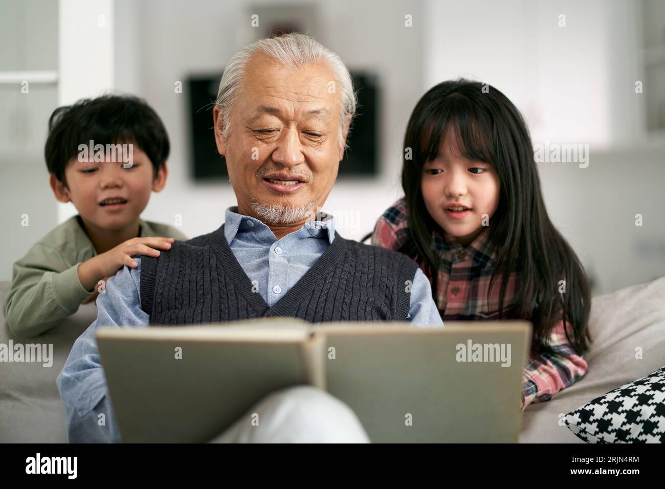 nonno asiatico anziano che si diverte con due nipoti a casa Foto Stock