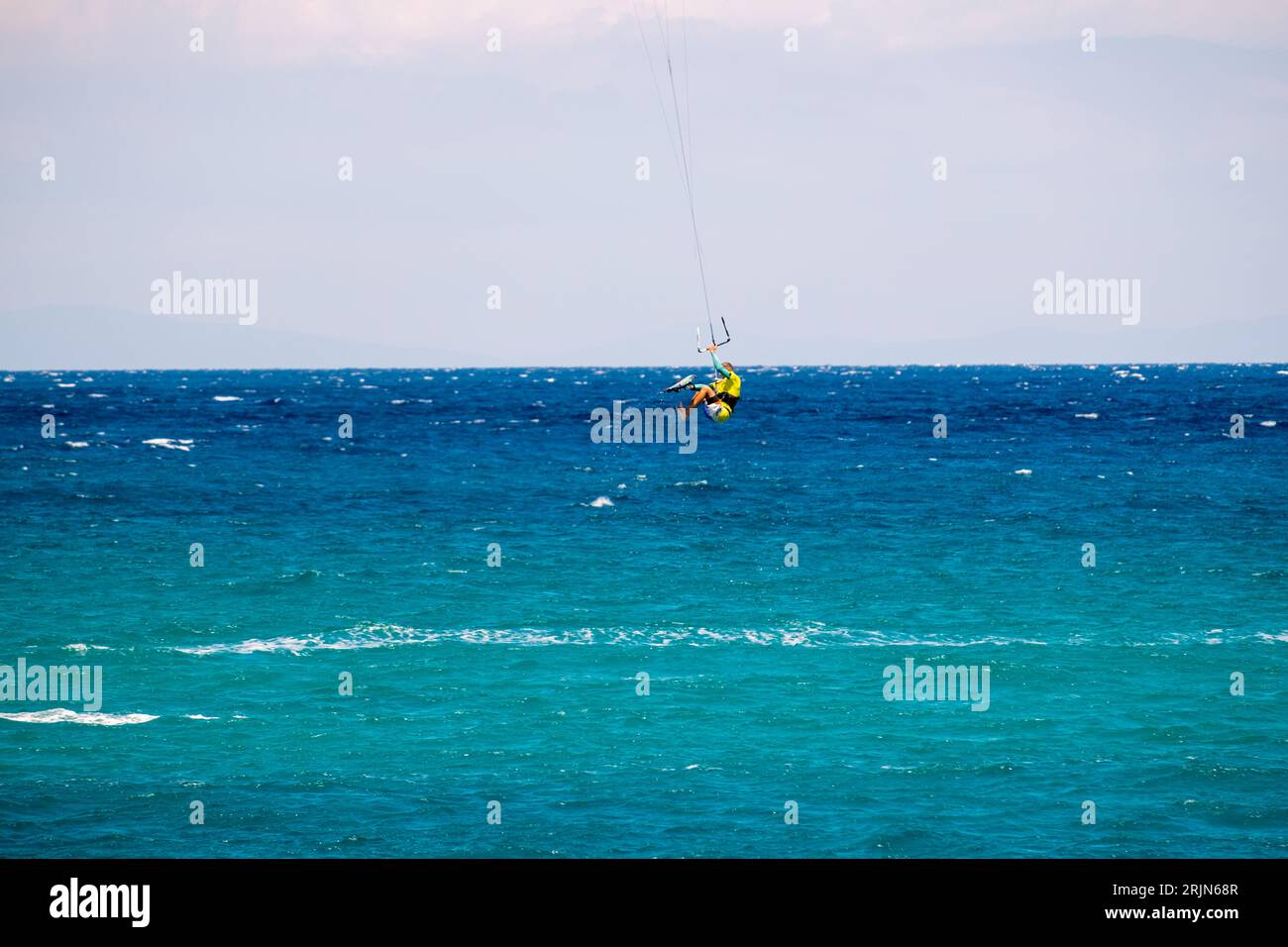 Il kite surfista sfreccia con la sua tavola in un cielo nuvoloso Foto Stock