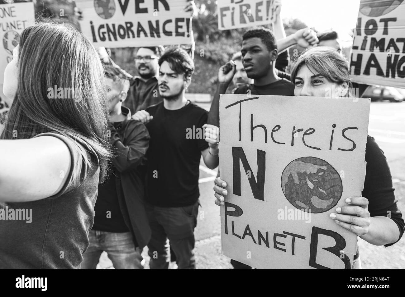 Le persone multigenerazionali protestano contro il cambiamento climatico - attivismo e concetto ambientale - Focus on right banner - editing in bianco e nero Foto Stock