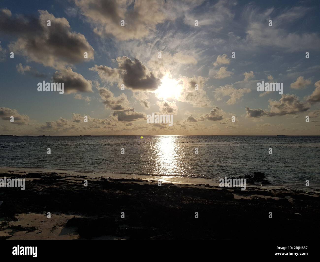 Il sole tramonta su un tranquillo paesaggio oceanico Foto Stock