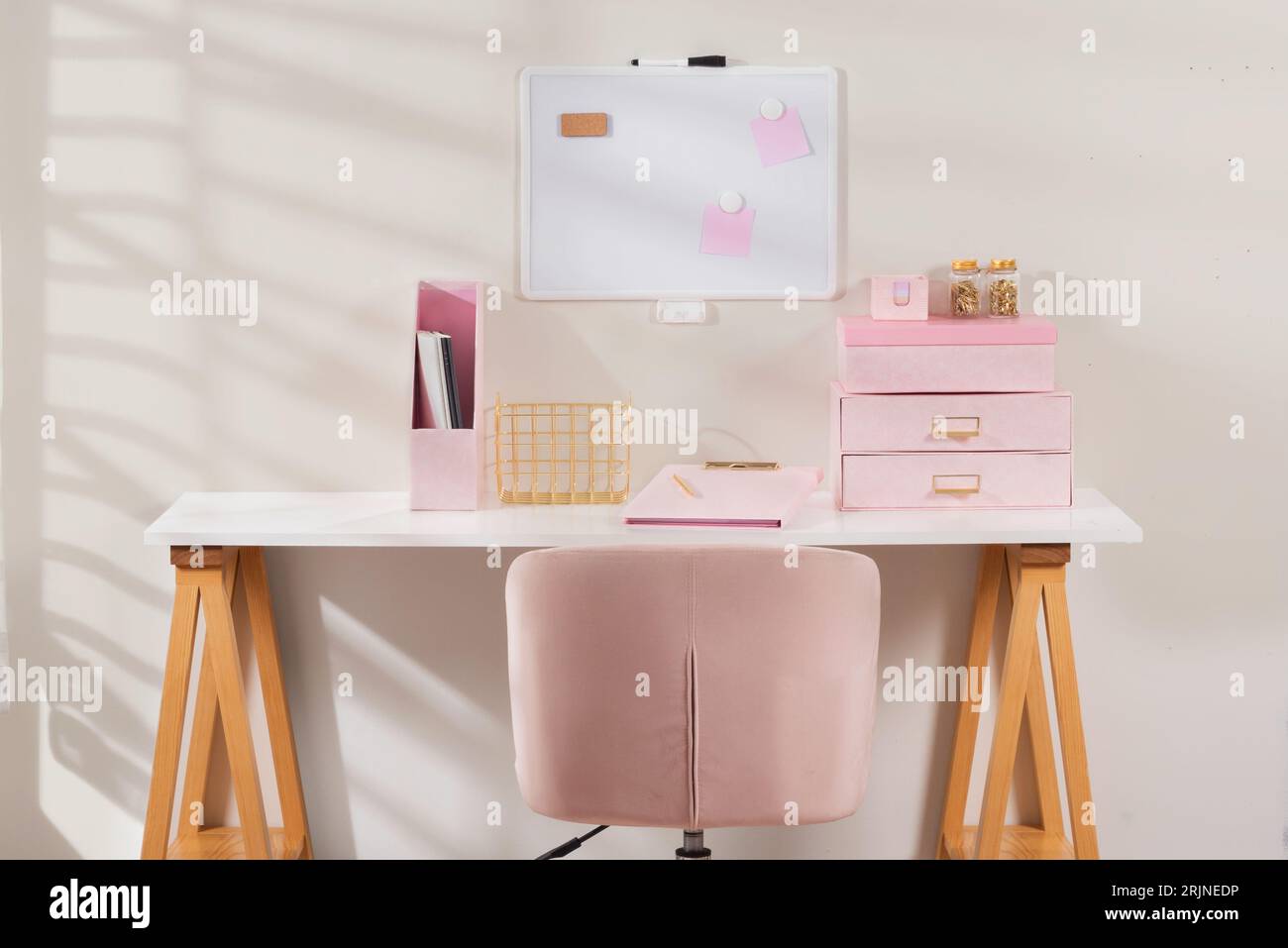 Questa immagine presenta un'elegante scrivania rosa con un set da scrivania coordinato Foto Stock