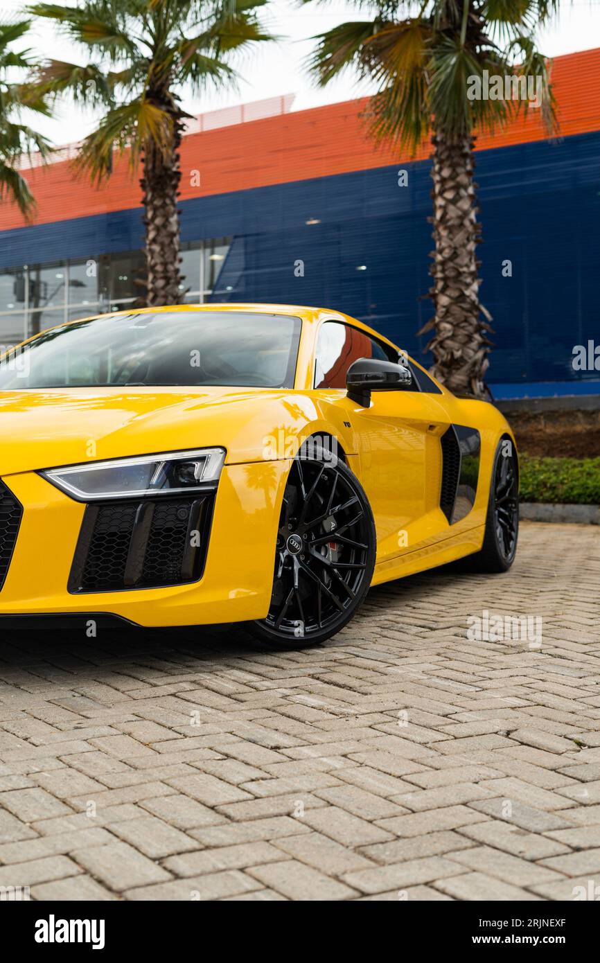 Una splendida Audi gialla parcheggiata su una strada lastricata in mattoni in una giornata di sole Foto Stock