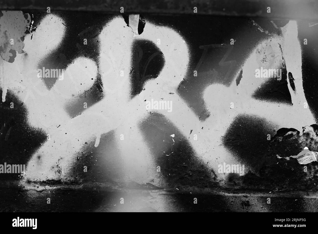 Spray ERA verniciato su una parete urbana industriale in bianco e nero. Foto Stock