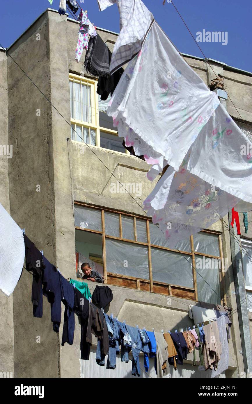 Bildnummer: 51009315 Datum: 03.12.2005 Copyright: imago/Xinhua Junge am Fenster eines Wohnhauses in Kabul vor dem Wäsche zum Trocknen auf einer Wäscheleine hängt - PUBLICATIONxNOTxINxCHN, Personen , Gebäude, außen Außenansicht; 2005, Kabul, kind, Kinder, afghane, afghanischer, afghanische, schaut, schauend, schauen , Fenster, Wäsche, trocknet, trocknend, hängt, aufgehängt, hängend, aufgehängte, Haus, Häuser, Leine, Leinen, Wäscheleine; , hoch, Kbdig, totale, Wohngebäude, Afghanistan, / Jungen Foto Stock