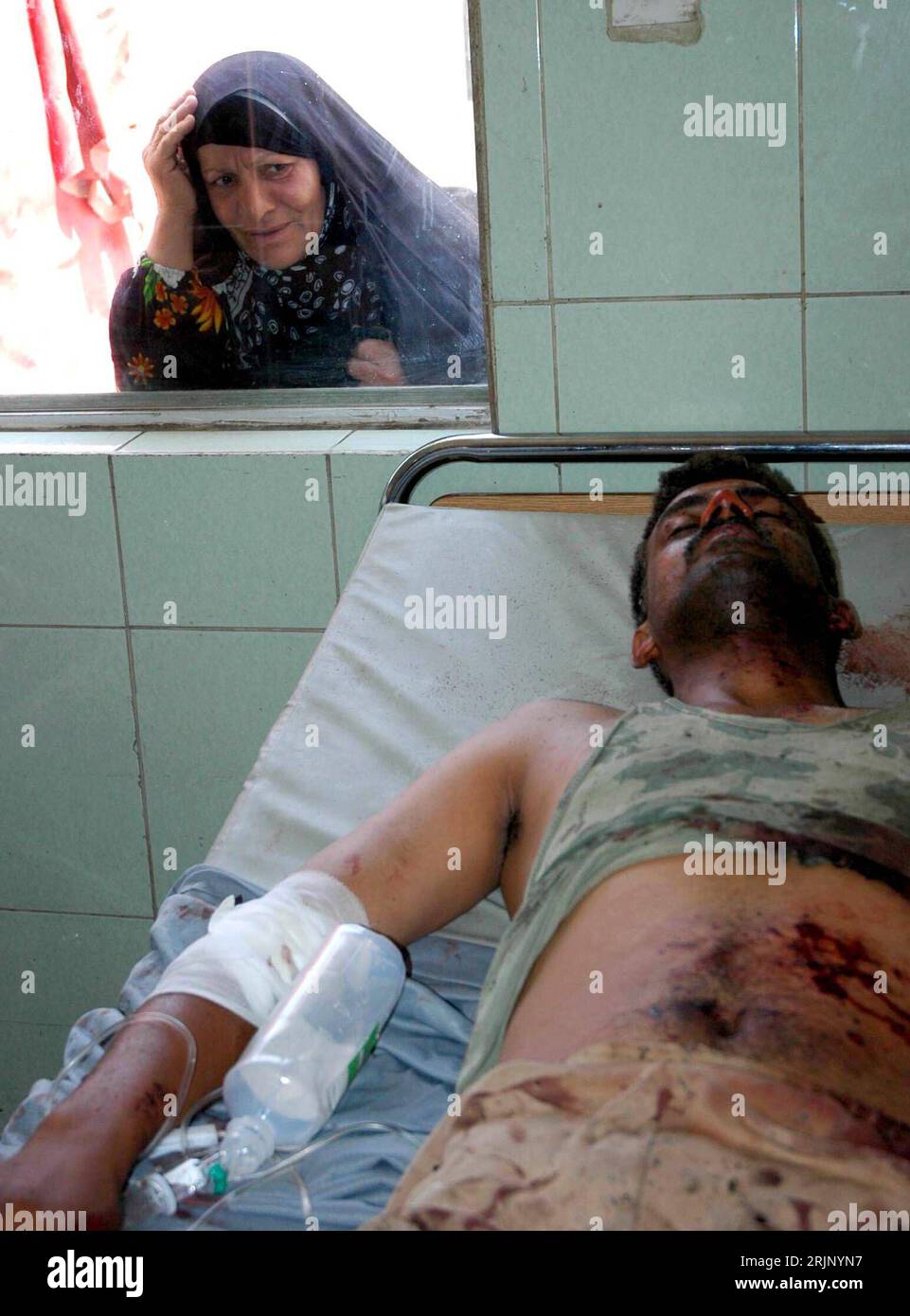 Bildnummer: 51038973 Datum: 20.07.2005 Copyright: imago/Xinhua Frau schaut durch ein Fenster eines Krankenhauses auf einen überlebenden Soldaten eines Bombenanschlages in Bagdad - PUBLICATIONxNOTxINxCHN, Personen; 2005, Bagdad, Krankenhäuser, verwundete, verletzt, Verletzter, Verletzte, Opfer, Verletzung, Verletzungen, schauen, schauend, Überlebender, Überlebende, Anschlag, Anschläge, Attentat, Attentate, terrore, Terrorismus, Selbstmordanschlag, Selbstmordanschläge, Terroranschlag, Terroranschläge, Bombenattentat, Bombenattentate, Bombenanschlag; hoch, Kbdig, Gruppenbild, Irak / verwundet, Foto Stock