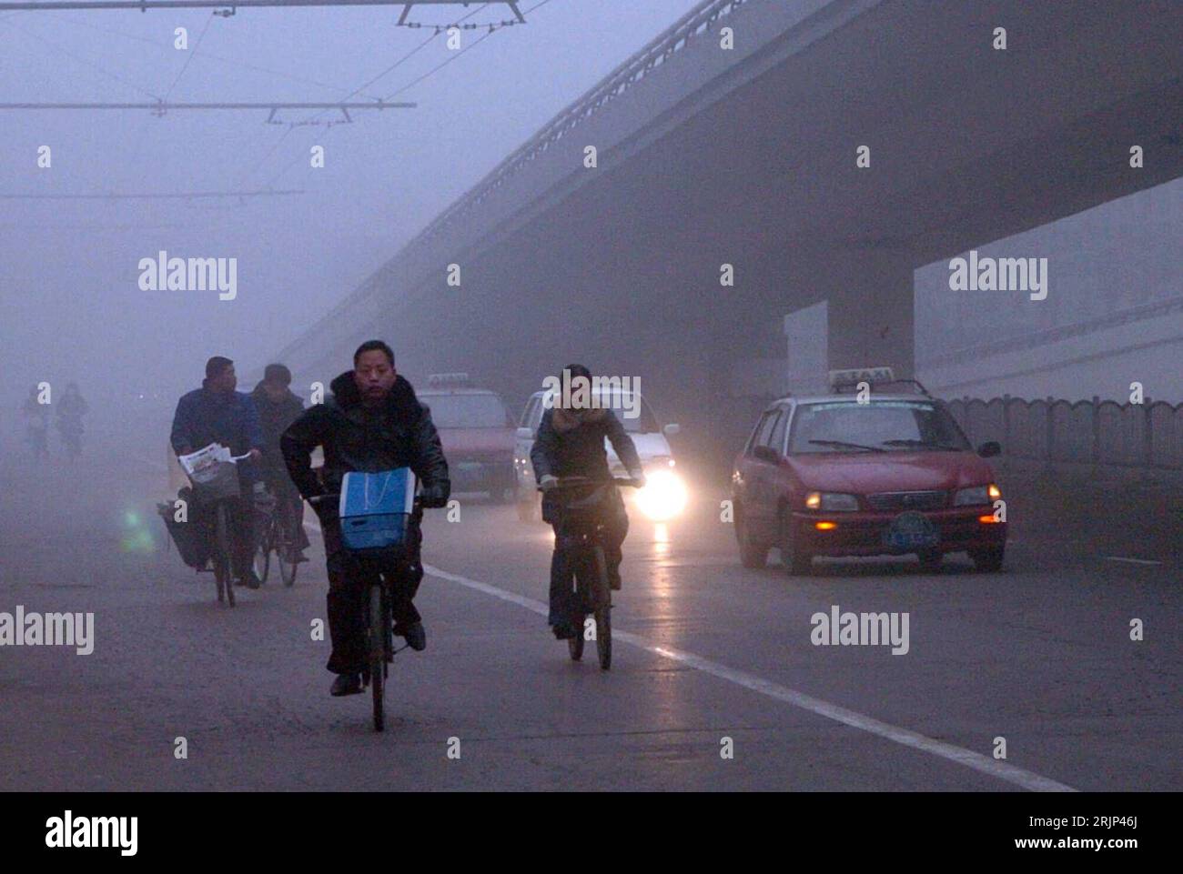 Bildnummer: 51081363 Datum: 28.01.2006 Copyright: imago/Xinhua Fahrradfahrer in Zhengzhou kämpfen sich durch dichten Nebel PUBLICATIONxNOTxINxCHN, Personen; 2006, Zhengzhou, Radfahrer, Fahrradfahren, Radfahren, Fahrräder, Räder, Rad fahren, Fahrrad, fahrend, fährt, Einheimischer, Einheimische, Land, Leute, dichter, neblig, Wetter, Witterung, Witterungsverhältnisse, Straßenverhältnisse, Sicht, schlecht, schlechte; , quer, Kbdig, totale, Cina, Straße, Verkehr, Foto Stock