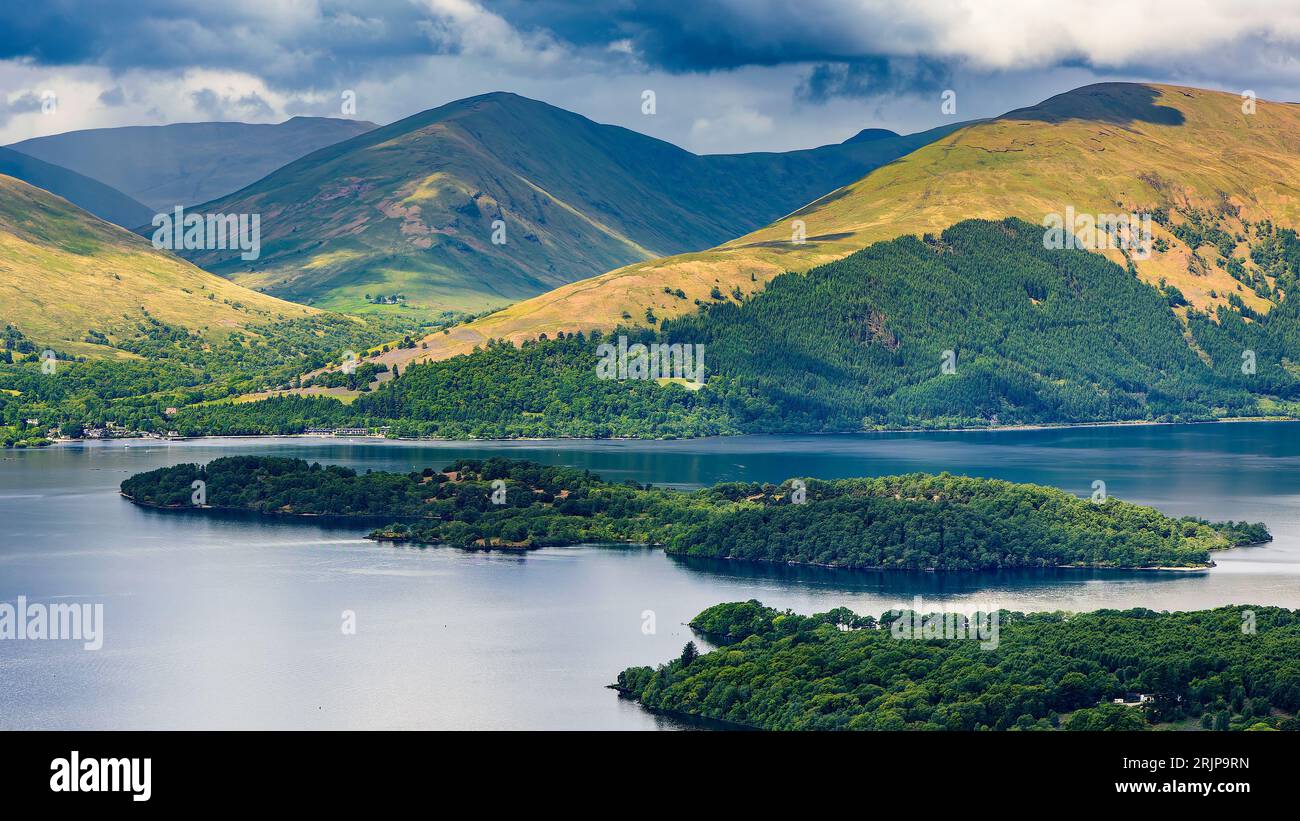 Splendido lago scozzese (lago) con isole circondate da montagne e un cielo spettacolare (Loch Lomond, Highlands) Foto Stock