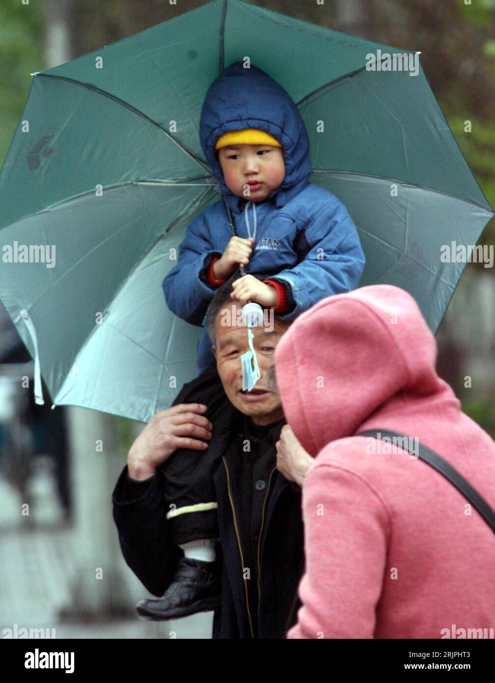 Bildnummer: 51192096 Datum: 12.04.2006 Copyright: imago/Xinhua Einheimische mit Kleinkind Schützen sich mit der richtigen Kleidung vor Wind und Regen in Jinan - PUBLICATIONxNOTxINxCHN, Personen; 2006, Jinan, Shandong, Witterung, Witterungsverhältnisse, Wind, windig, windiges, Wetter, Stürme, Regen, Regenwetter, Regenkleidung, Regenbekleidung, Regenjacke, Regenjacken, Regenmantel, Schutzkleidung, Regenschirm, Regenschirme, passante, Passanten, Cinese, Chinesen, Einheimischer, Einheimische, kind, Kinder; , hoch, Kbdig, Gruppenbild, close, Cina, Foto Stock