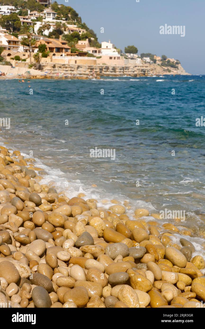 Una spiaggia soleggiata ad Alicante, in Spagna, caratterizzata da rocce marine strutturate in una varietà di forme Foto Stock