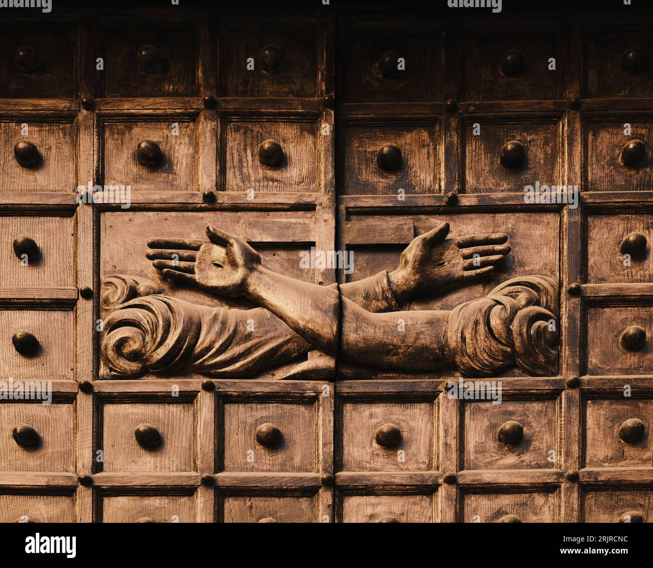 Questa foto mostra una scultura in legno scolpita di una figura maschile e femminile, ognuna con una mano sollevata Foto Stock