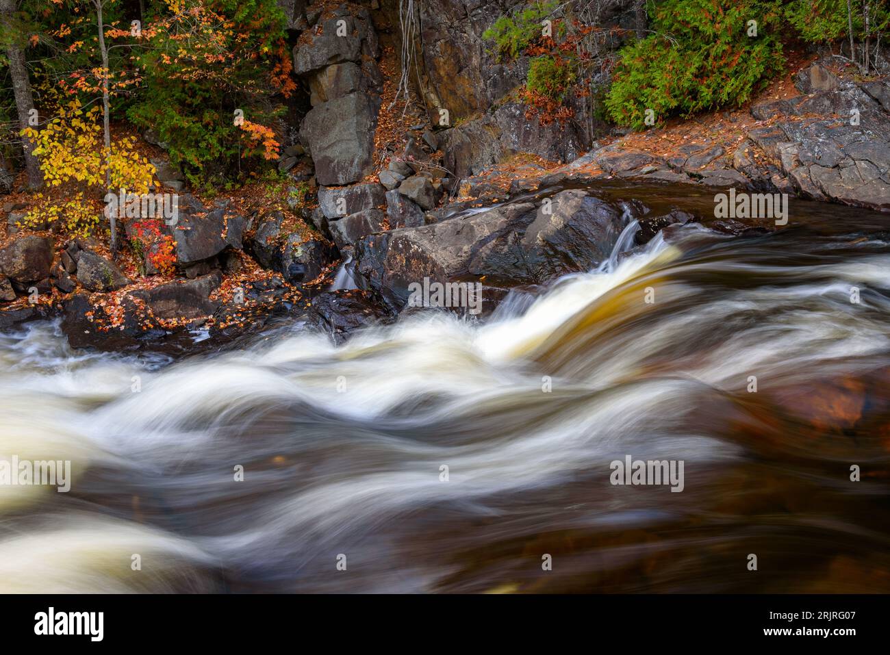 Primo piano di rapide acque fluide vicino alla cima della cascata su un fiume di montagna in autunno Foto Stock