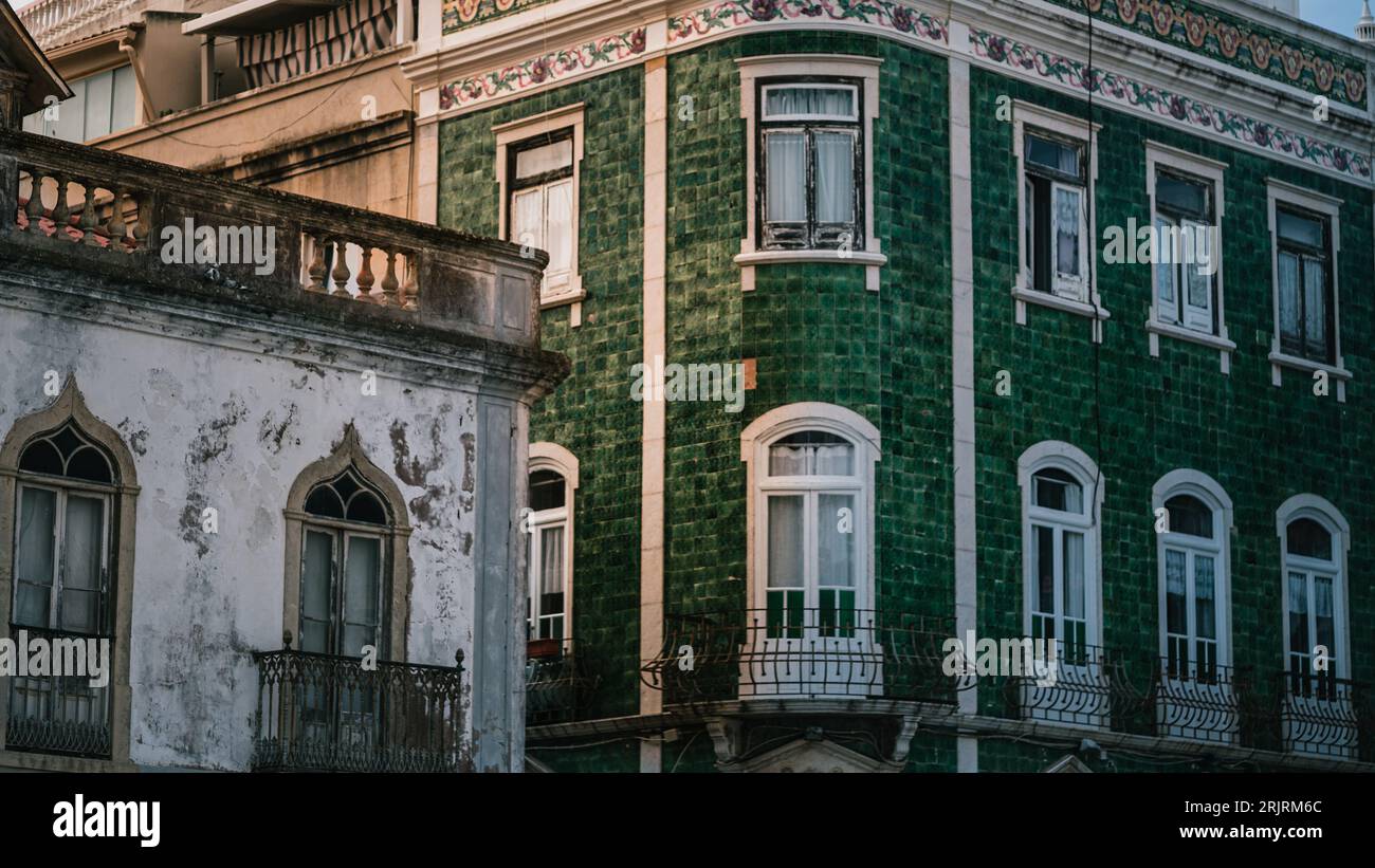 Una foto esterna di un grande edificio di piastrelle verdi situato in Portogallo, con un edificio più piccolo vicino Foto Stock