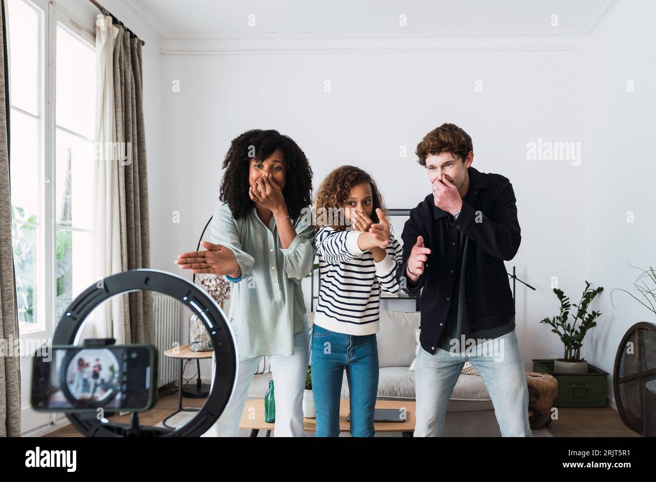 Famiglia felice che filma un video divertente in salotto Foto Stock