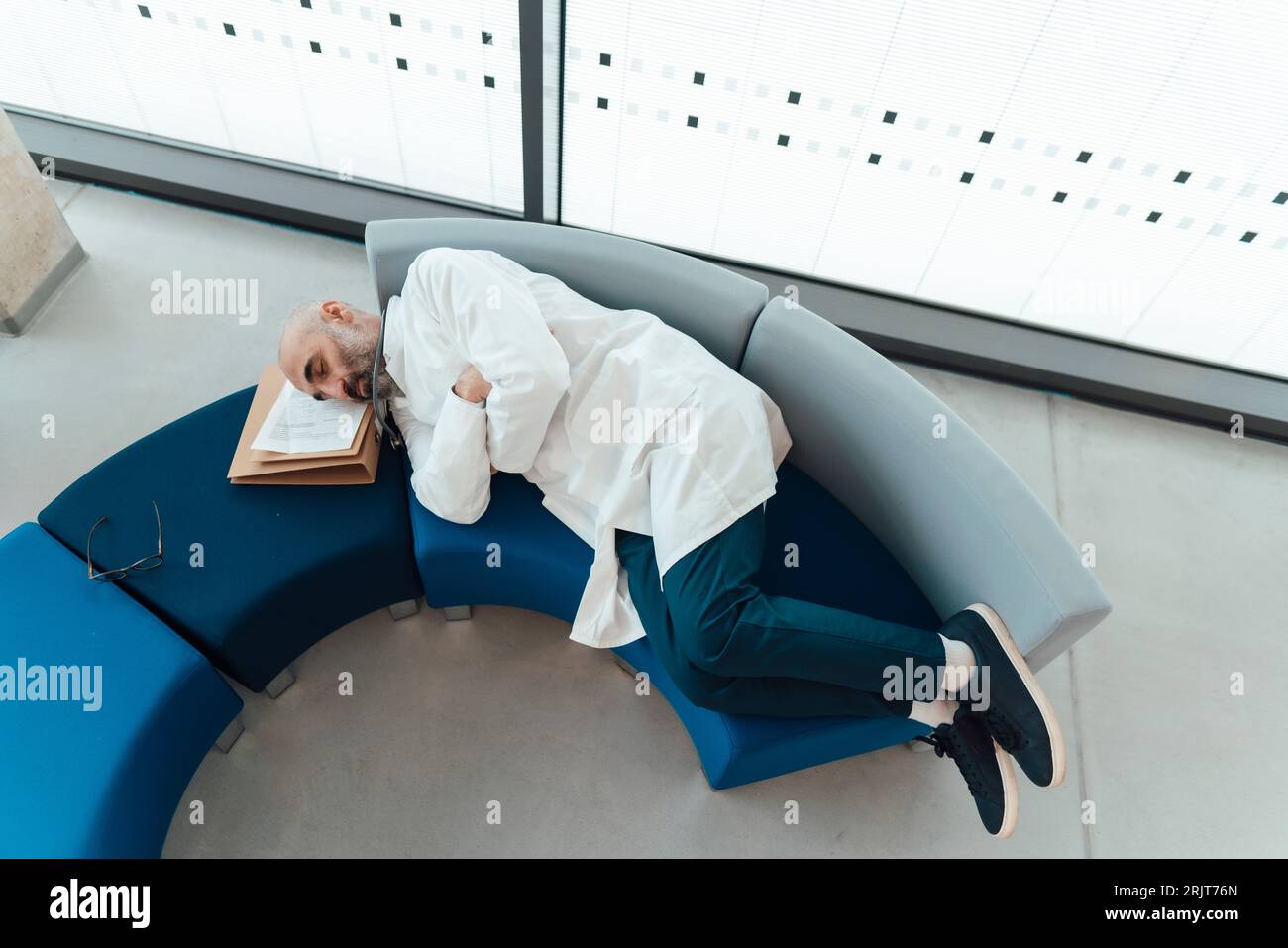 Medico stanco che riposa sul divano in ospedale Foto Stock